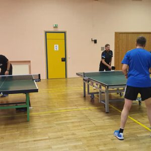 Foto vom Tischtennistraining im Turnerheim-Saal, es sind drei Tische zu sehen an denen gerade gespielt wird