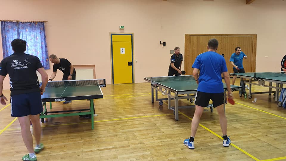 Foto vom Tischtennistraining im Turnerheim-Saal, es sind drei Tische zu sehen an denen gerade gespielt wird